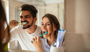 couple brushing teeth for dental implant care in Worthington