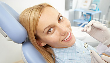 Smiling woman receiving a dental exam from a dentist
