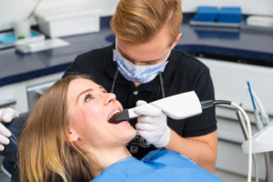 Dentist scanning the teeth of patient with CEREC scanner