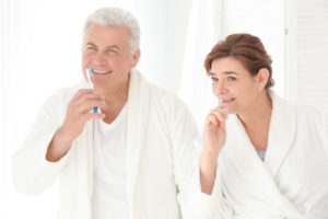 Senior couple cleaning teeth at home